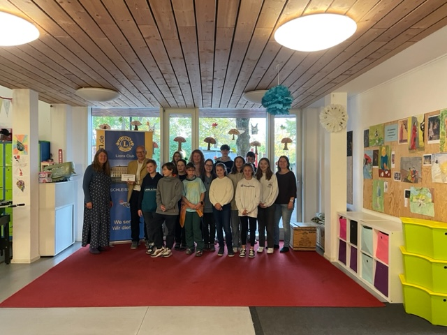 Schüler:innen und Lehrer:innen in der Autla mit Lionsclub Aufsteller.